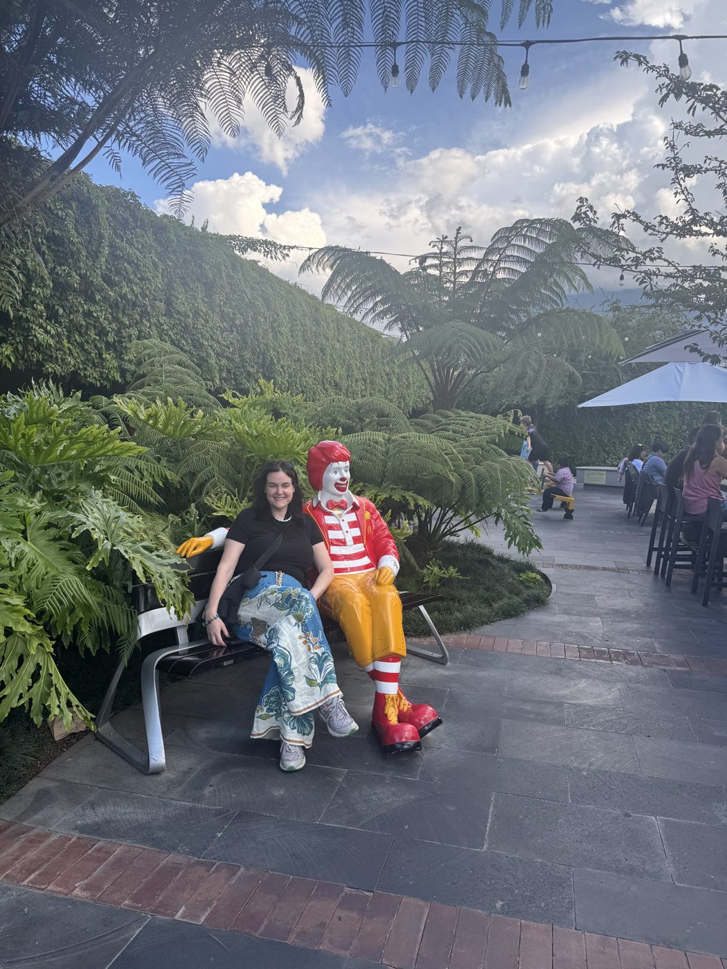 Sitting next to a Ronald McDonald statue in the courtyard of McDonald's Antigua